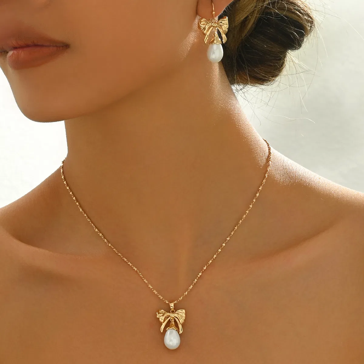 Elegant Gold-Toned Bow & Pearl Jewelry Set - Halskette & Ohrringe